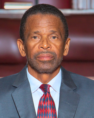 The Hon. Dennis Lister, JP,MP